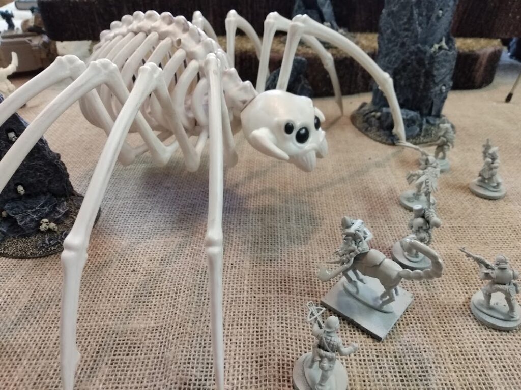 Large Halloween spider skeleton facing off against toy soldiers